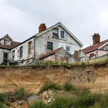 A house near a cliff edge in Hapisburgh, Norfolk, UK